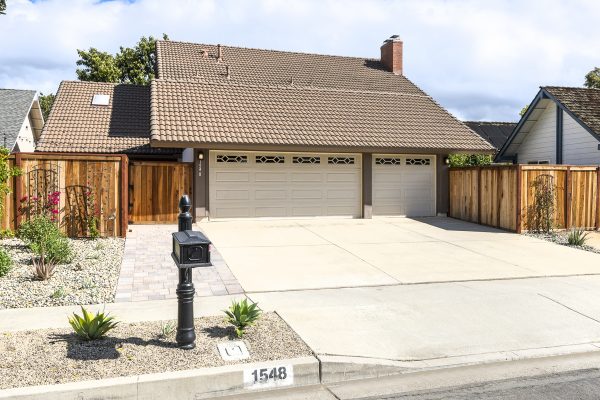 Double garage with fence, sidewalk, and mailbox