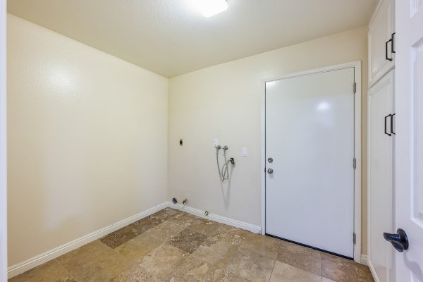 Door leading outside next to washer/dryer hookups with tile floor