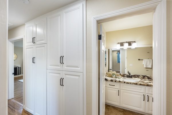 Hallway outside bathroom with 8 cabinets