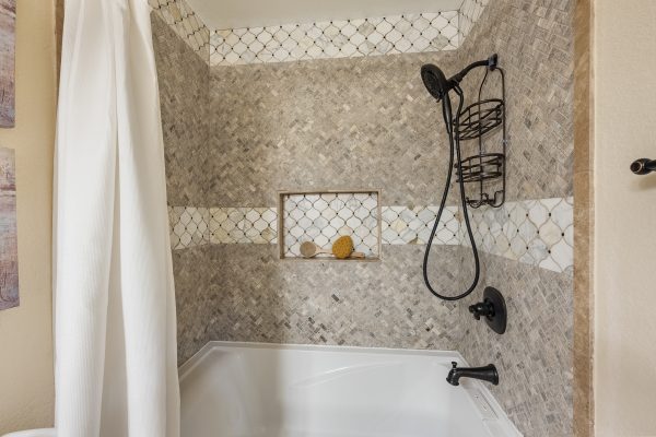 Bathtub with removable shower head and tiled walls