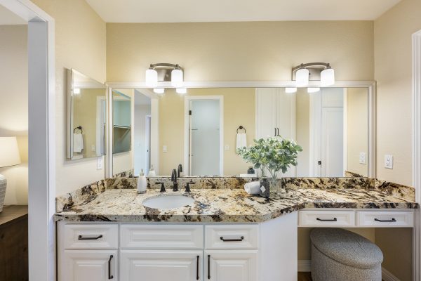 Master bathroom with one sink, marble counters, and large mirror