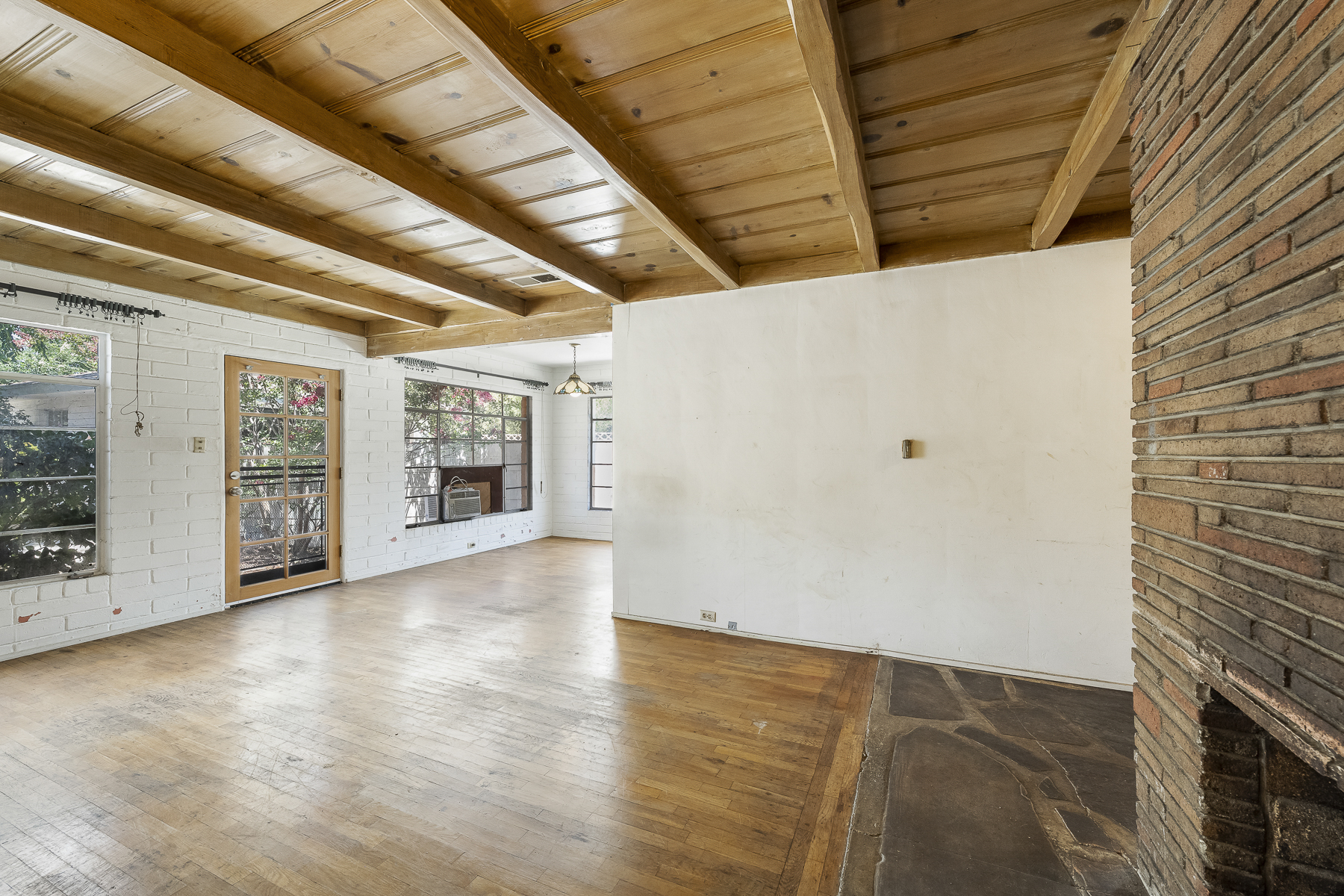 319 E. Francis Ave, La Habra, CA 90631: Interior shot of living room, fireplace, back door and wood panel ceiling.